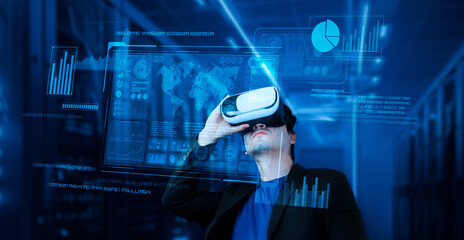 Businessman with headset standing at data center while analyzing financial data. Manager looking...