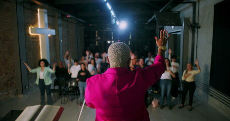 Church service with pastor leading praise and prayer, congregation actively participating with...