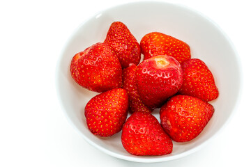 Fresh strawberries in white bowl on white background
