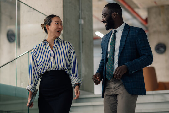 Businesspeople walking and talking in modern office building