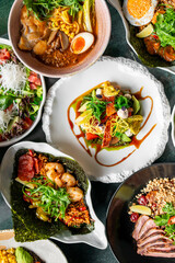 A vibrant assortment of gourmet dishes including fresh salads, ramen, seafood, and meat, beautifully plated with colorful ingredients, showcasing culinary artistry and appetizing presentation