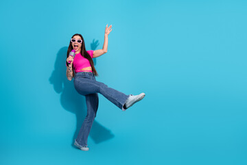 Excited Young Woman Singing and Posing with Confidence Against a Vibrant Blue Background,...