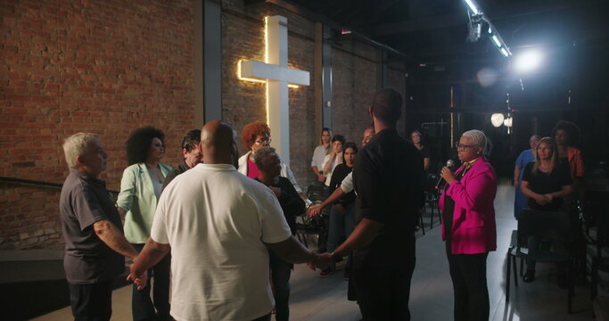Group of people holding hands in prayer during church service, pastor leading spiritual moment, community united in faith and prayer, evangelical Christian worship