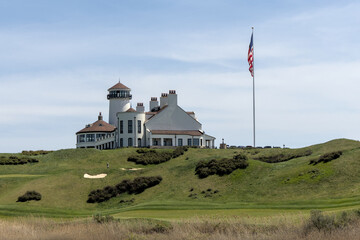 white building on green meadow grass hill next to american flag of the united states of america usa...