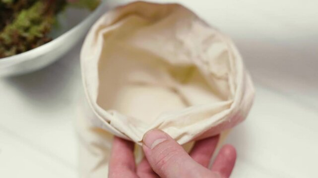Closeup of spring fresh salad leaves in an eco bag. Process of preparing veggies for cooking. Local food concept.	

