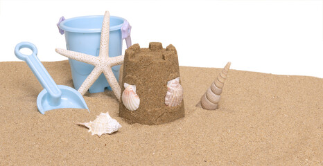 Seau de plage, jeux et coquillage sur un fond de sable de plage