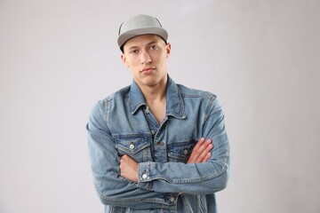 Young man in stylish baseball hat on light grey background