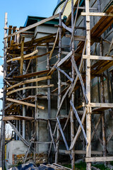 Wooden scaffolding near the old building. Ancient building restoration