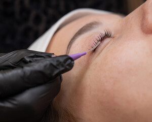 The process of professional eyelash lamination in a salon. 