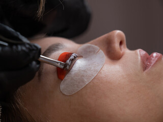 Caucasian woman undergoing eyelash lamination procedure. 