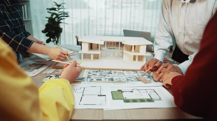 A dynamic scene depicting architects collaborating over blueprints and sketches in a contemporary office, highlighting teamwork and creative design processes in architecture. SACTR