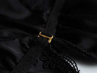Close up of black fabric and gold clasp on women's underwear