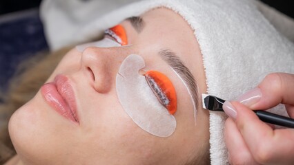 Caucasian woman undergoing eyelash lamination procedure. 