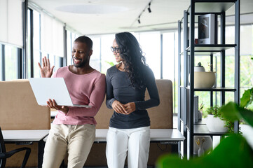 Smiling Young Black Male and Asian Woman Collaborating in Bright Modern Office