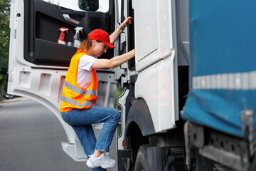 Portrait young adult happy smiling woman climbing cabin heavy truck driver cargo vehicle. Female person girl professional job career working driving freight engine lorry. Logistics industry