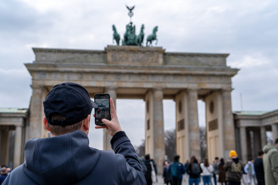 turista paseando por la Pariser Platz en Berl&iacute;n, Alemania, y tomando una foto en la Puerta de Brandeburgo