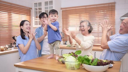Happy Asian family preparing food together in a bright kitchen, sharing joyful moments with a toddler during a fun and healthy cooking time - Powered by Adobe