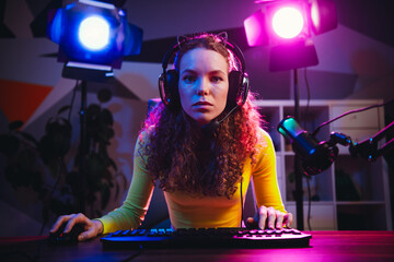 Young female streamer gaming with neon lights in an atmospheric setup