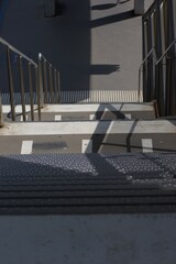 Striking shadows and strong lines define this urban staircase, showcasing modern design and stark contrasts in light and dark.