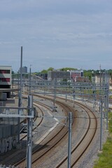 Curving train tracks dominate this urban landscape, reflecting the dynamic flow of transportation under a bright sky.