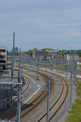 Curving train tracks dominate this urban landscape, reflecting the dynamic flow of transportation under a bright sky.