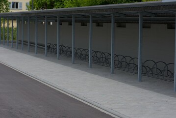 A row of sturdy metal bike racks under a minimalist shelter, showcasing practical urban design and organized storage solutions.