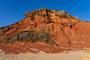 Telheiro beach at sunset in Sagres, Portugal, with its colorful cliffs.