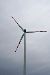 Single wind turbine producing clean energy on a cloudy, overcast day. Renewable power and...