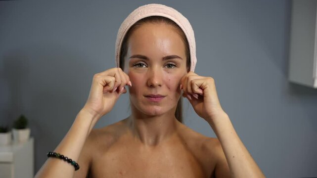 Woman massaging cheeks with knuckles during lifting routine