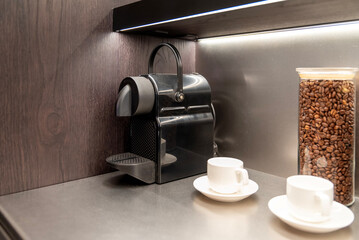 Capsule coffee machine with cups and jar of roasted beans