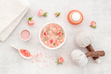 Roses essence water in bowl with petals and skin care cosmetic products with flowers essential oil
