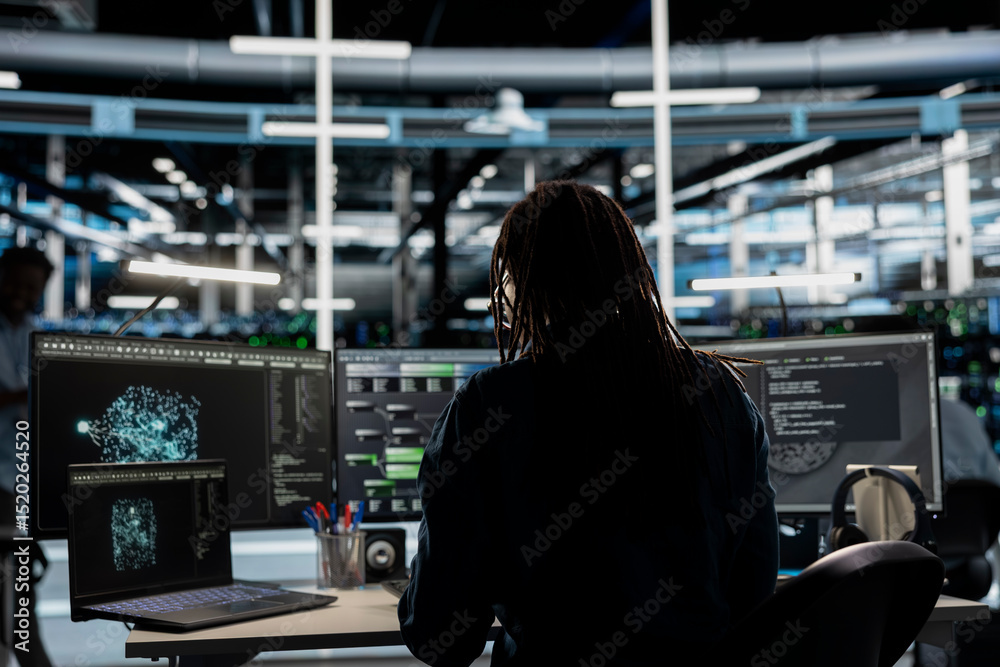 Poster data center admin looks at ai visualization dashboard on laptop to pinpoint equipment performance is