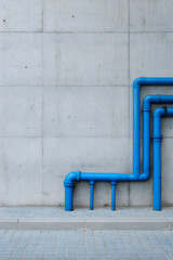 Blue municipal water pipes on concrete wall