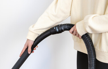 Close-up of a woman cleaning her apartment with a professional vacuum cleaner.
