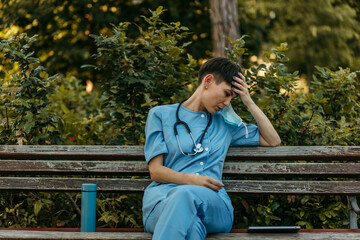 Exhausted nurse taking a break on park bench