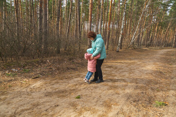 Grandmother with granddaughter walking in nature in the forest