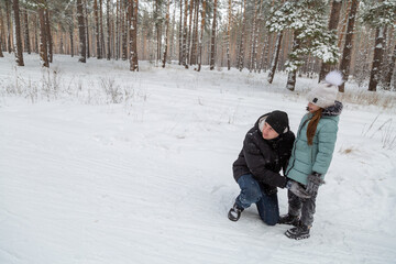 Fototapeta premium Dad and daughter walking and having fun in snowy winter forest