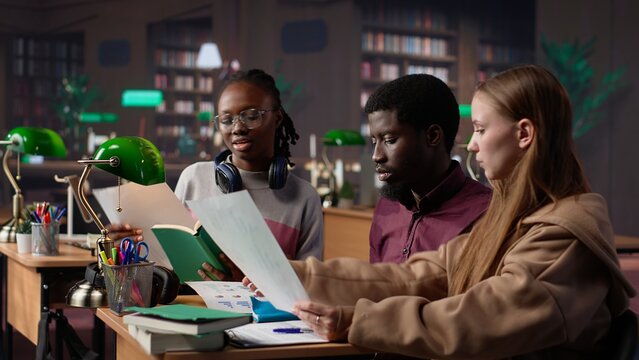 College students collaborating on startup project in the campus library, focusing on international business administration and management. Studying hard for their academic degree. Camera A.