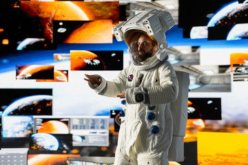 Young male cosmonaut drifting in zero gravity during a space walk, reflecting interstellar...