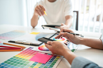 Team of creative graphic designer working on color swatch samples chart for selection coloring in inspiration to create new collection at workplace
