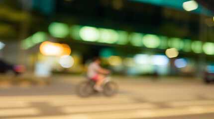 Fototapeta premium Blurred city lights with a cyclist in motion, capturing night energy.