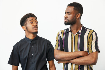 Black men engaging in a friendly conversation, showcasing emotions of joy and camaraderie. The warm colors and relaxed attire create a welcoming atmosphere.