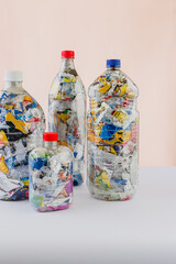 Group of four bottles of PET stuffed with plastic wrappers waste for upcycling and eco bricking