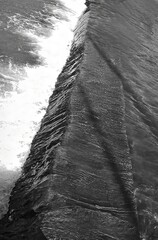 Vertical, black and white image. River mountain rapids. Dynamic composition. Abstract forms.