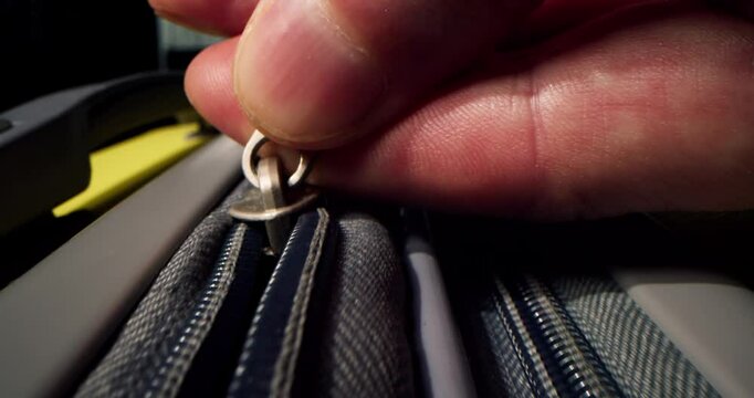 Zipper on suitcase. Zipping closing yellow travel luggage. Unrecognizable fingers pull zipper tab. Packing bags journey, adventure and fascinating exploration. Vacation dreams, preparation for travel