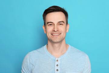 Smiling man after shaving on light blue background