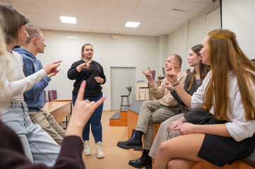 Young people communicate in sign language in a university classroom. 