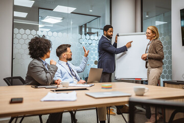Man and woman tutors present project on whiteboard to diverse colleagues