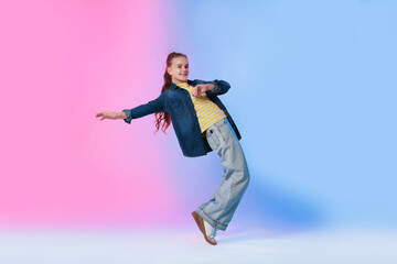 Girl in stylish clothes dancing on color background