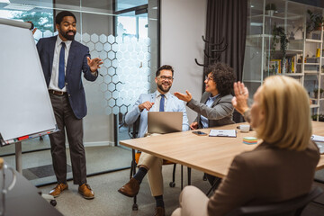 Man tutor present project on whiteboard to diverse colleagues